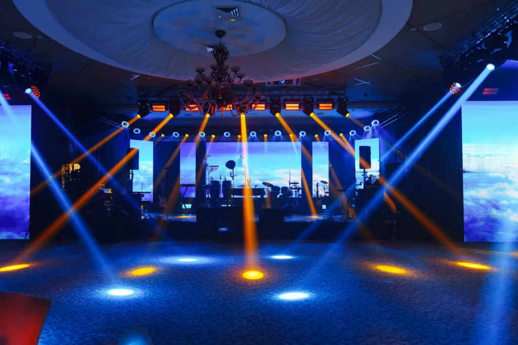 Concert stage with colorful spotlights and musical instruments.