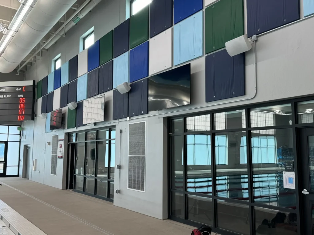 Indoor swimming pool area featuring wall-mounted speakers and colorful panels for visual and audio enhancements.